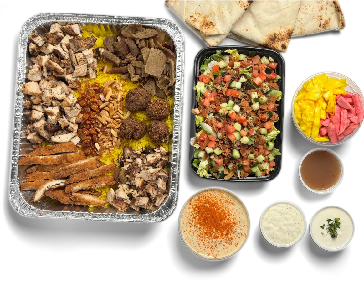 Pita Way catering spread with a protein and rice tray, fattoush salad, pita, hummus, pickles and sauces